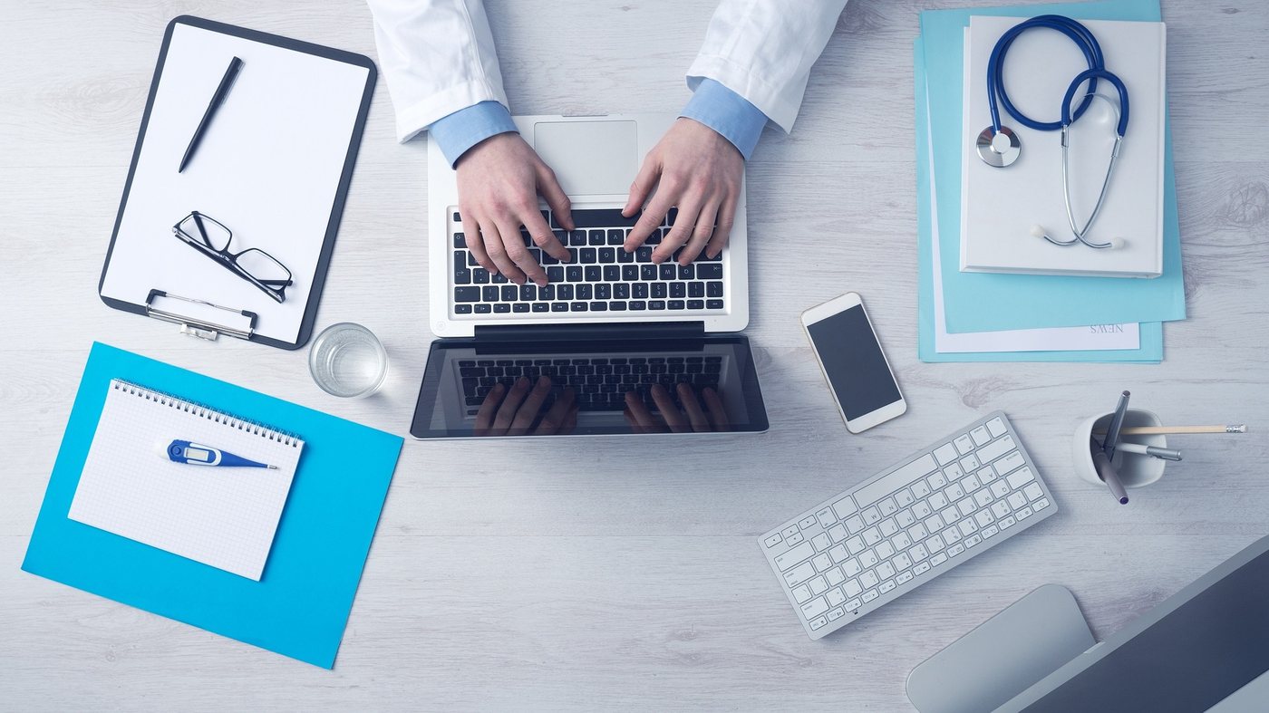 Birou de consultanță medicală și laptop, imagine pentru analizarea opțiunilor de asigurare